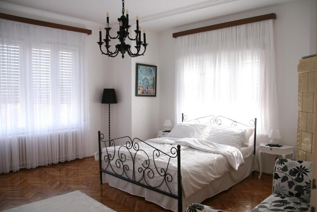 诺维萨德Apartment Kalina的一间卧室配有一张带白色床单和吊灯的床。