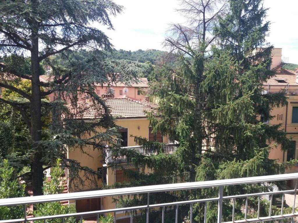博洛尼亚Relais Lola的从树木繁茂的建筑的阳台上可欣赏到风景