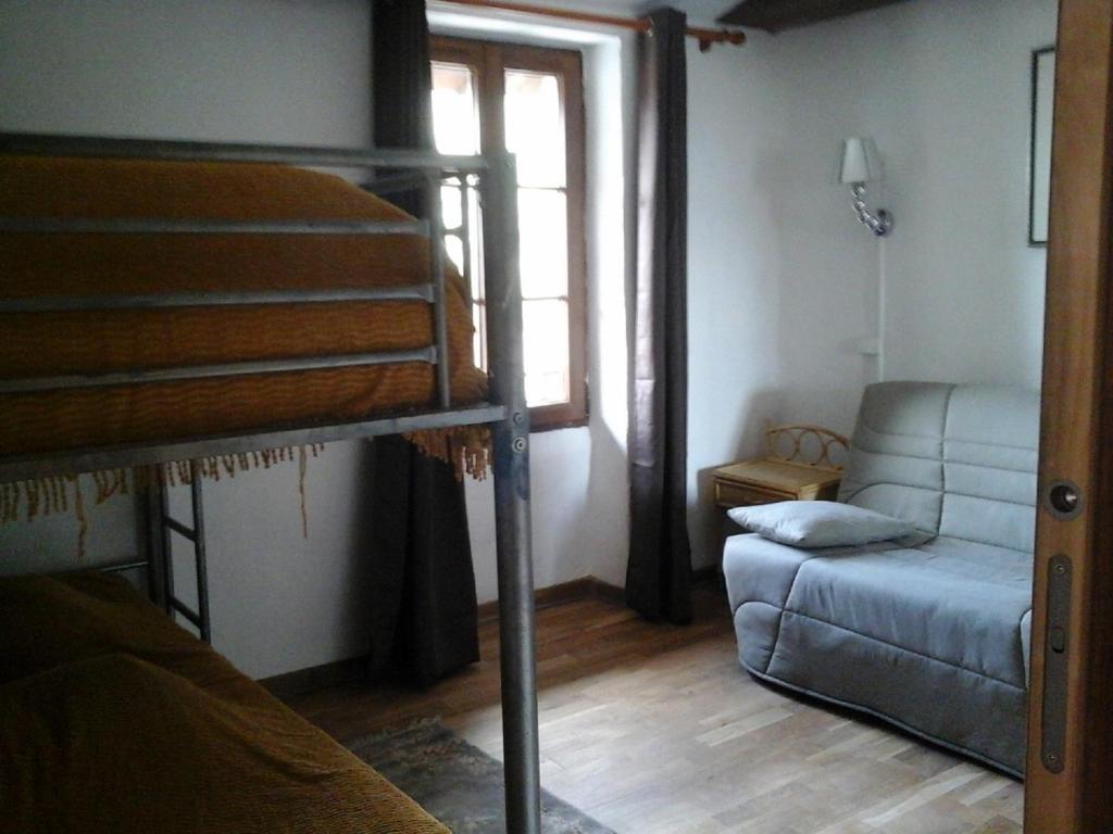 瓦尔代布洛尔les Millefonds的宿舍间设有双层床和沙发。