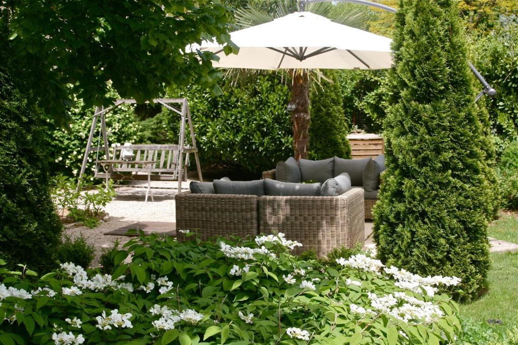 贝桑松莫利纳别墅酒店的一个带沙发和遮阳伞的花园