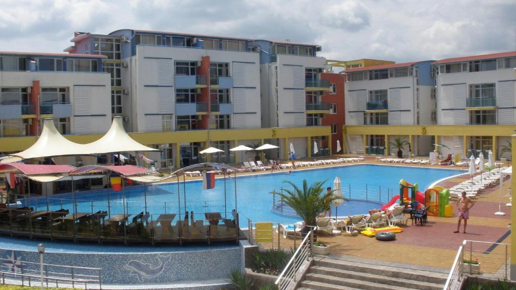 阳光海滩艾丽特3号综合公寓楼公寓之音酒店的一个带椅子的大型游泳池和一间酒店