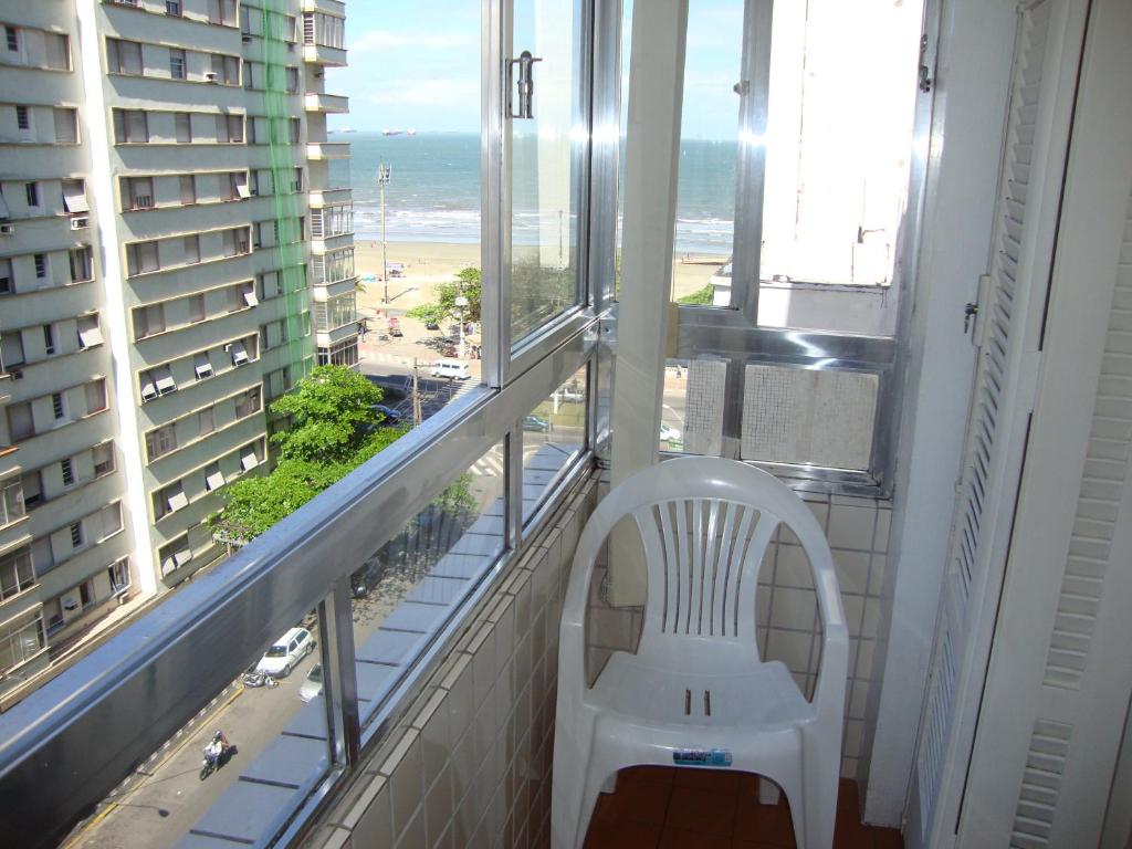 桑托斯Recanto Santista的海滩景阳台的白色椅子