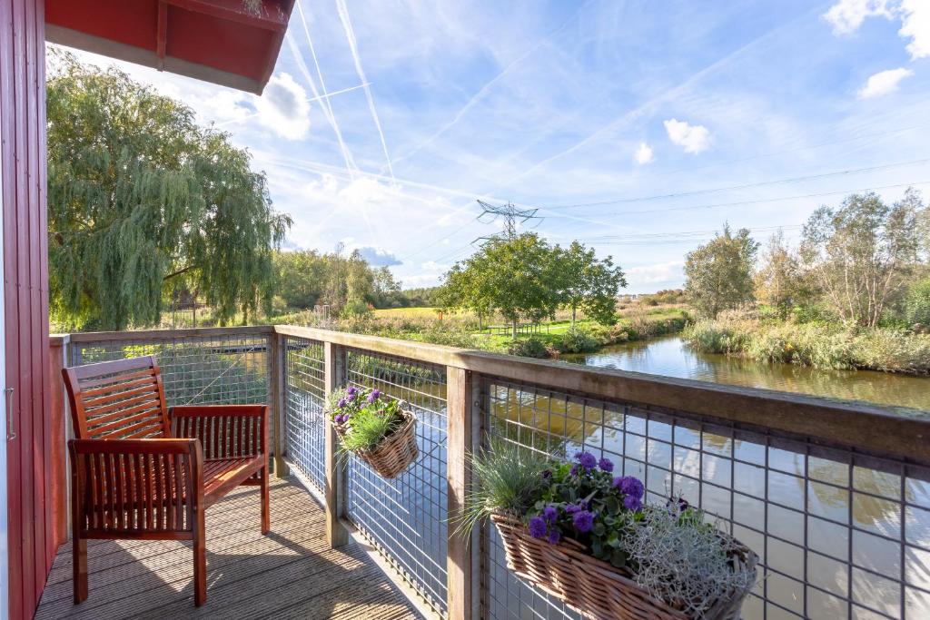 莱利斯塔德鸬鹚餐厅的阳台配有椅子,享有河景