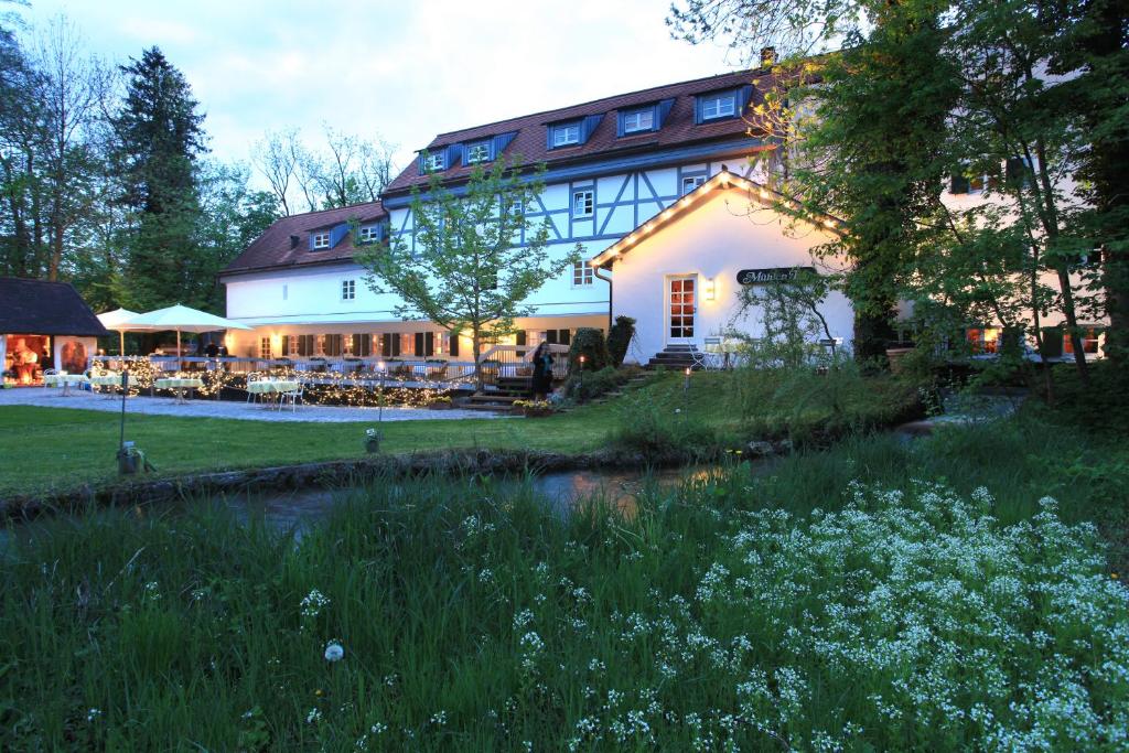 慕尼黑Naturglück Inselmühle的前面有池塘的大房子
