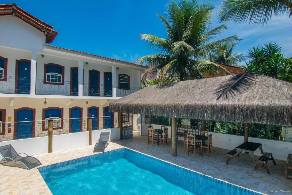 帕拉蒂Pousada Lua Clara的一座别墅,设有游泳池和棕榈树