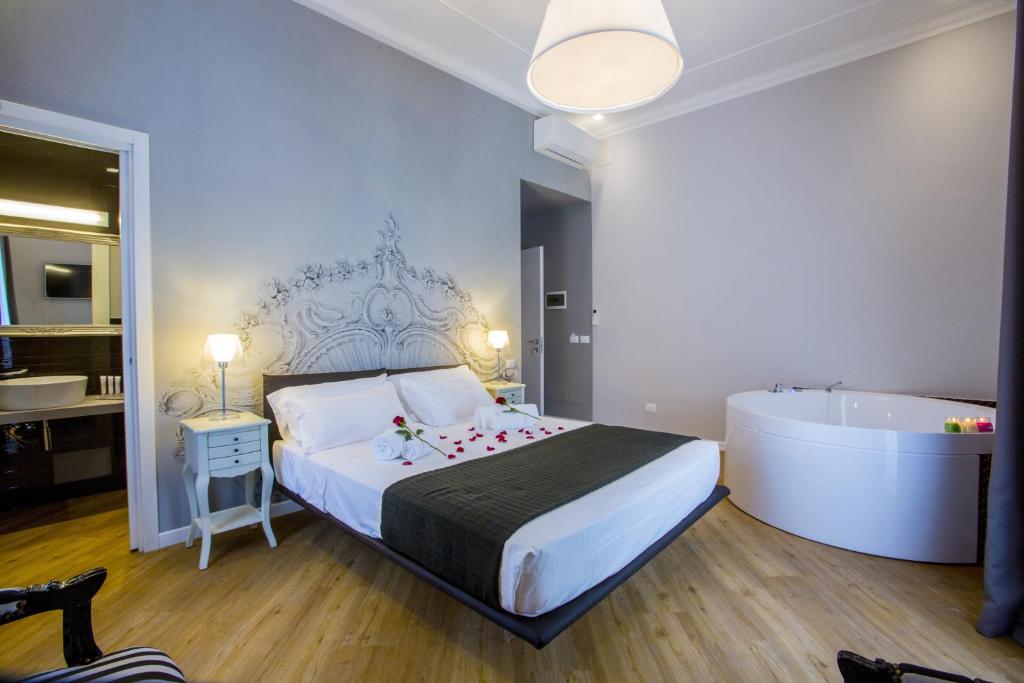 罗马阿拉旅馆的一间卧室设有一张大床和一个浴缸