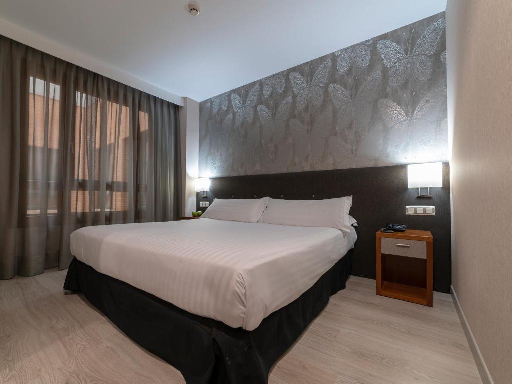 拉斯·罗萨斯·德·马德里拉斯麦塔斯广场酒店的酒店客房设有一张大床和大型床头板