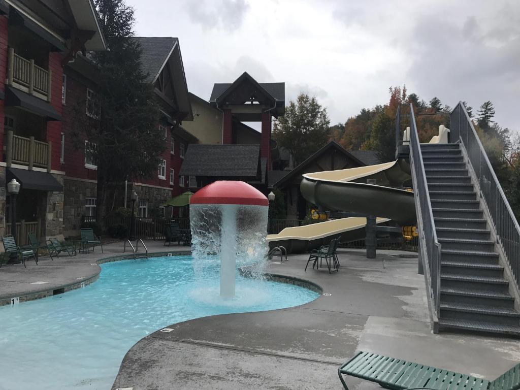 加特林堡The Appy Lodge的一座建筑中间的游泳池,有一个喷泉