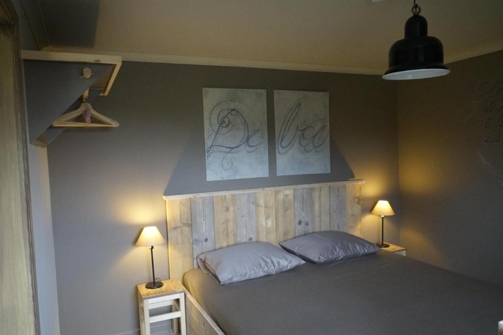 马塞克Kampenhof的一间卧室配有一张带两个枕头和两个灯的床。