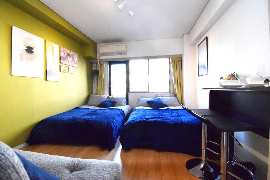 东京LIONS APARTMENT 516的一间卧室配有两张床和钢琴