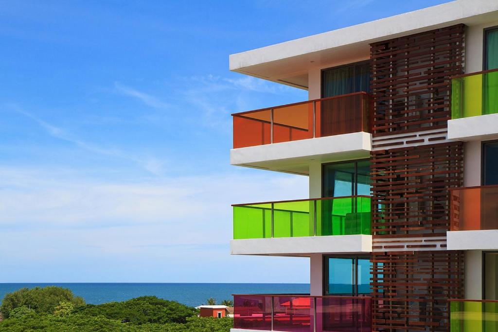 华欣Rocco Hua Hin Beach Seaview的一座建筑,设有色彩缤纷的阳台,背面是大海