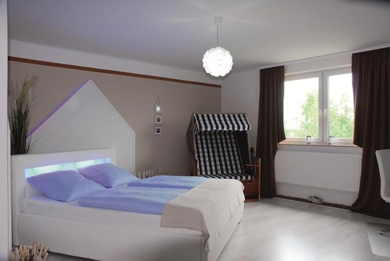 伊森比特尔罗森霍夫酒店的一间卧室配有一张带蓝色床单的床和一扇窗户。