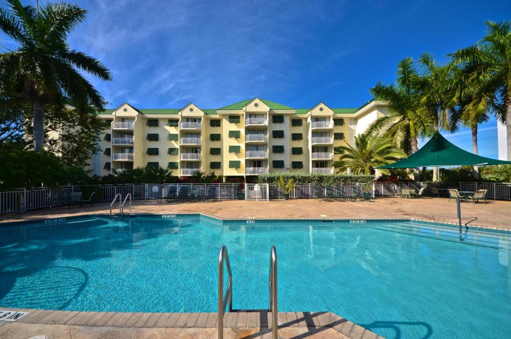 基韦斯特Sunrise Suites Barbados Suite #204的棕榈树度假村前的游泳池