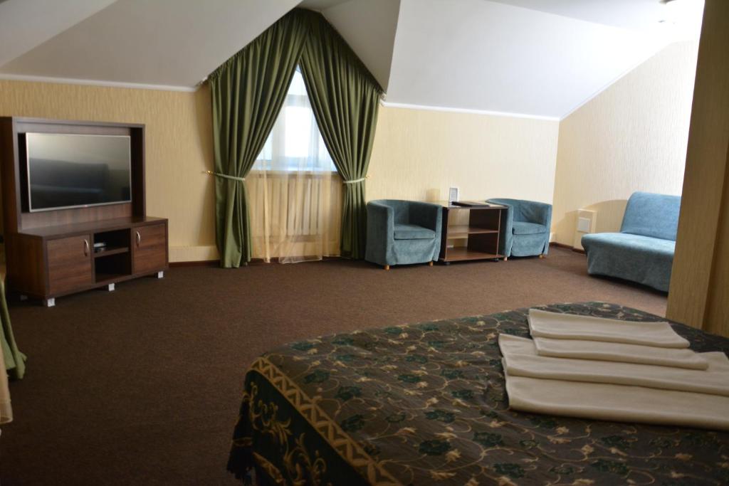 乌拉尔斯克Tropicana Inn的配有一张床和一台平面电视的酒店客房
