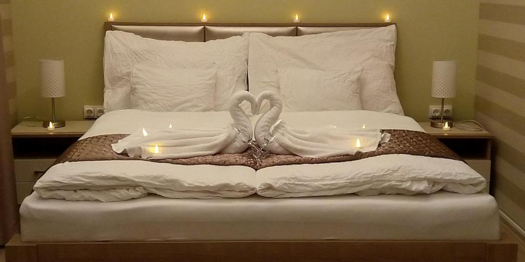 德布勒森Ditta Panzio的一间卧室配有一张带两个天鹅的床