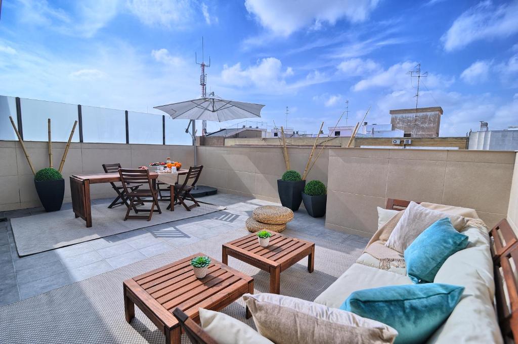 瓦伦西亚圣维森特HQ客房公寓的屋顶上设有带沙发和桌子的庭院。
