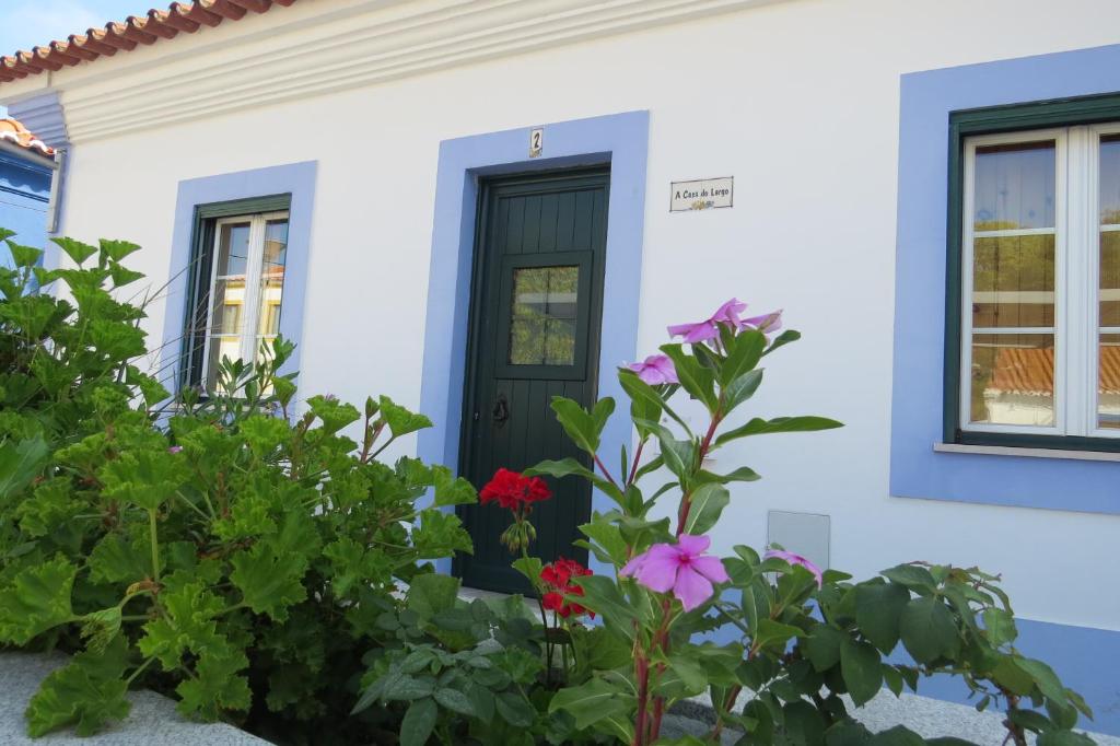 萨尔堡Casa do Largo的白色的房子,有黑色的门和鲜花