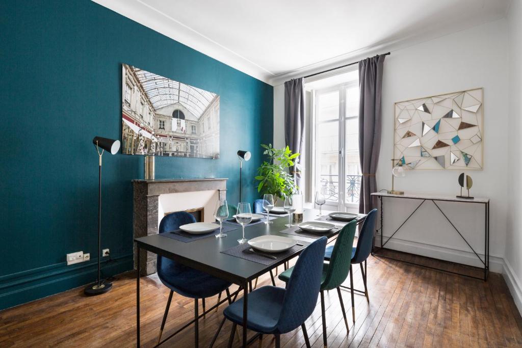 南特Le Prestige by Cocoonr的一间设有黑桌和蓝色墙壁的用餐室
