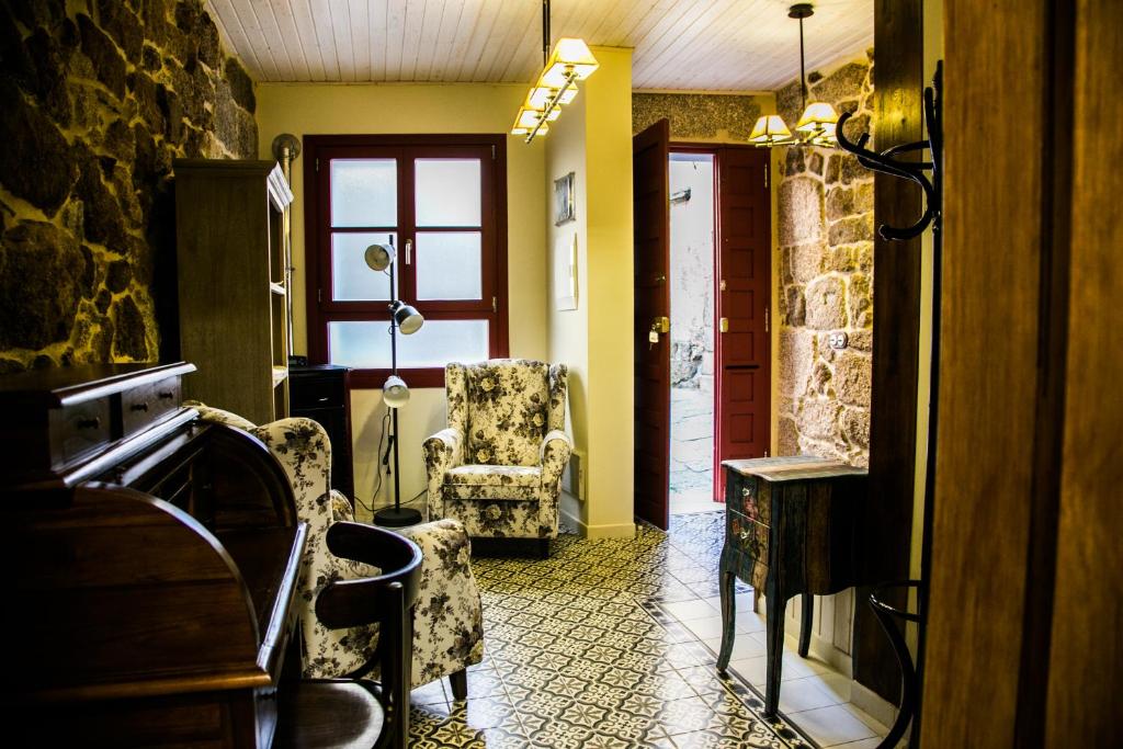 里瓦达维亚A casa da Igrexa的走廊设有两把椅子、一张桌子和一个窗户