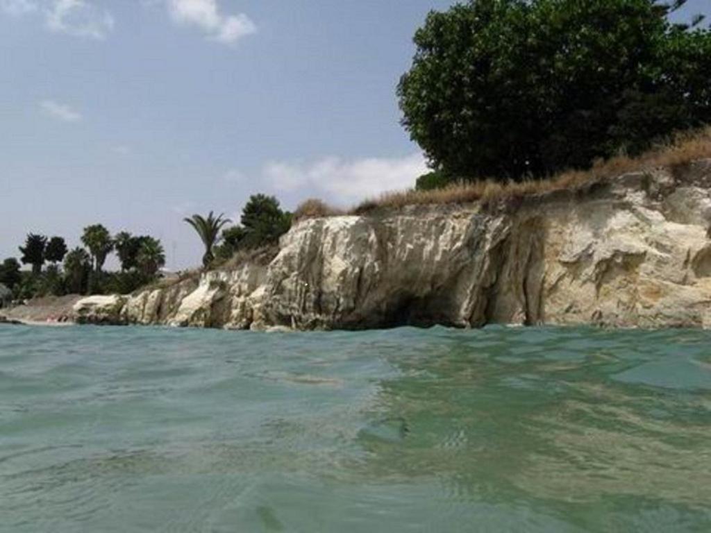 阿雷内拉桃金娘与玫瑰酒店的岩石海岸旁的水中的一个岛屿