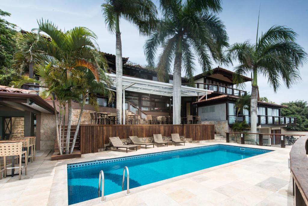 布希奥斯Ilha Branca Exclusive Hotel的一座带游泳池和棕榈树的房子
