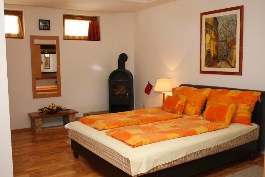 豪特万Motel 60的一间卧室配有一张带橙色枕头的床和壁炉