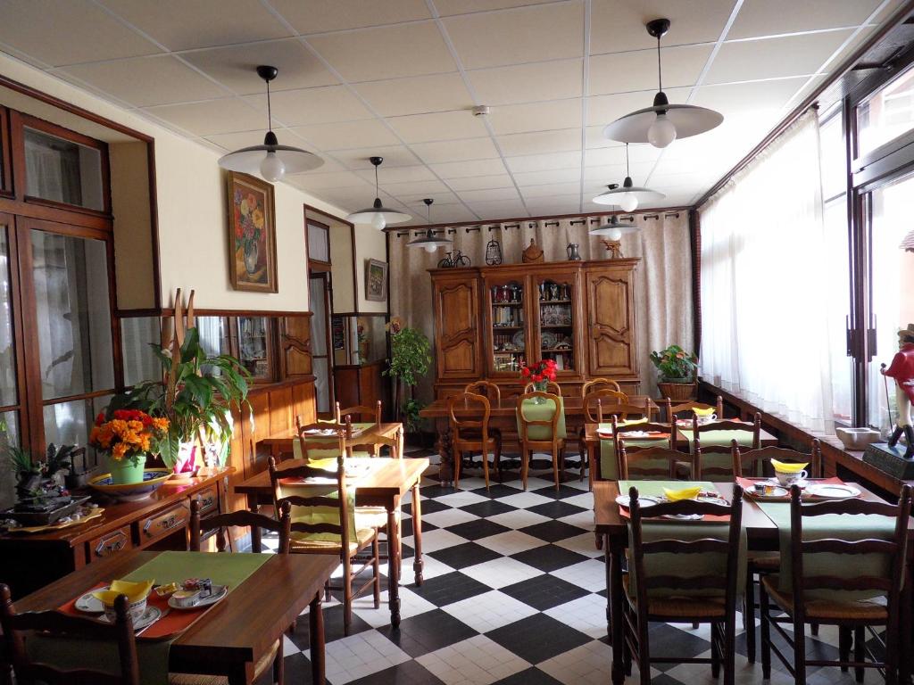 格勒诺布尔Hôtel Victoria的一间带桌椅和 ⁇ 制地板的餐厅