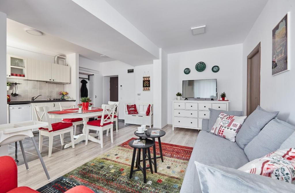 锡纳亚George Apartment Sinaia的客厅以及带沙发和桌子的厨房。