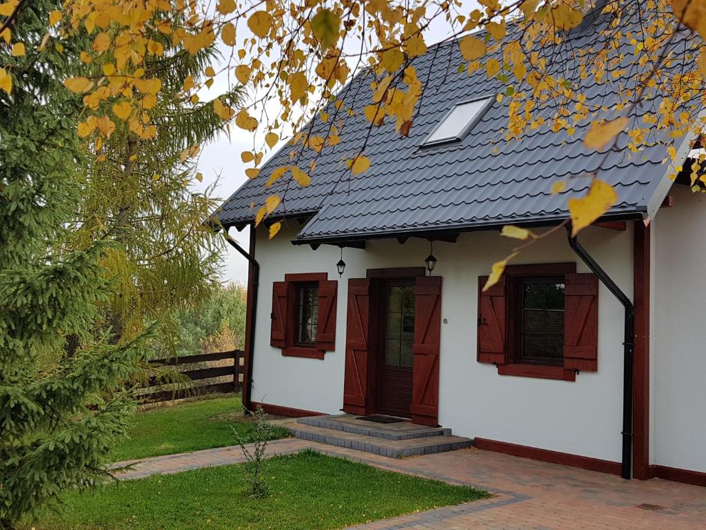 Skoszewo4 Pory Kaszub - Domek z banią i sauną的一间白色的小房子,设有红色的窗户和屋顶