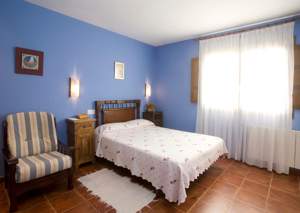 纳维亚苏琴乡村酒店的卧室配有床、椅子和窗户。