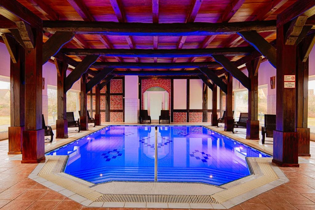 Gerswalde海伦斯廷斯赫劳斯酒店的一座大型游泳池,位于一座拥有大型天花板的建筑内