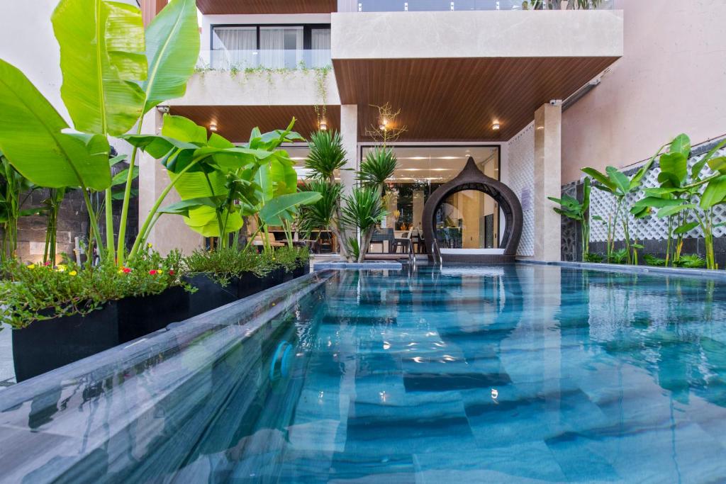 会安Khong Cam Garden Villas的植物繁茂的建筑中间的游泳池