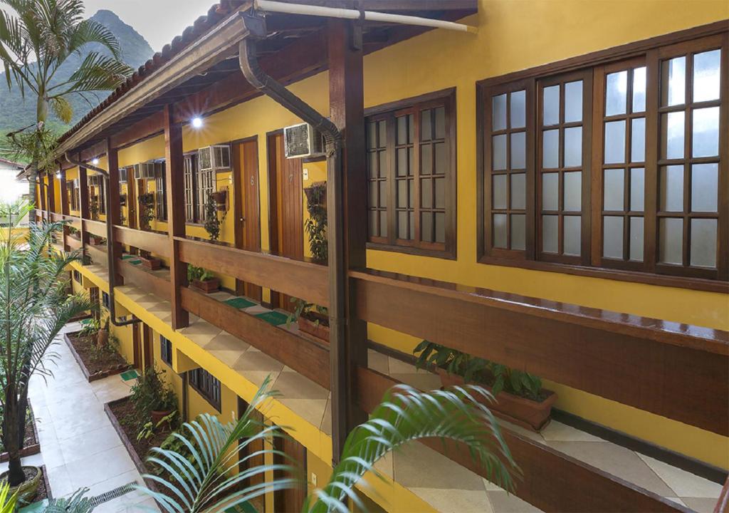 阿布拉奥罗尼尔普拉亚公寓酒店的黄色建筑,有窗户和植物