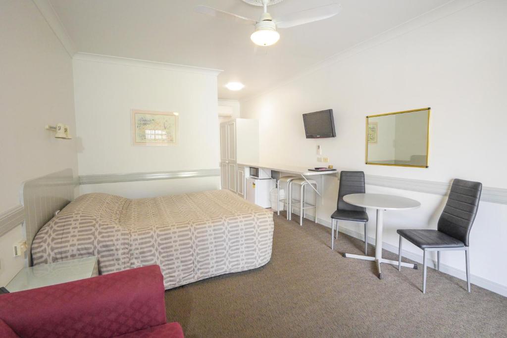 纳甘比镇中心汽车旅馆的卧室配有一张床和一张桌子及椅子