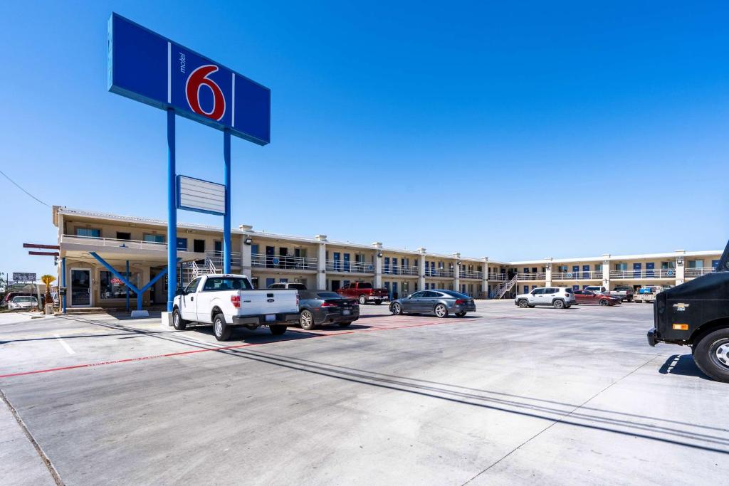 奥德萨Motel 6-Odessa, TX - 2nd Street的加油站,停泊在停车场的汽车