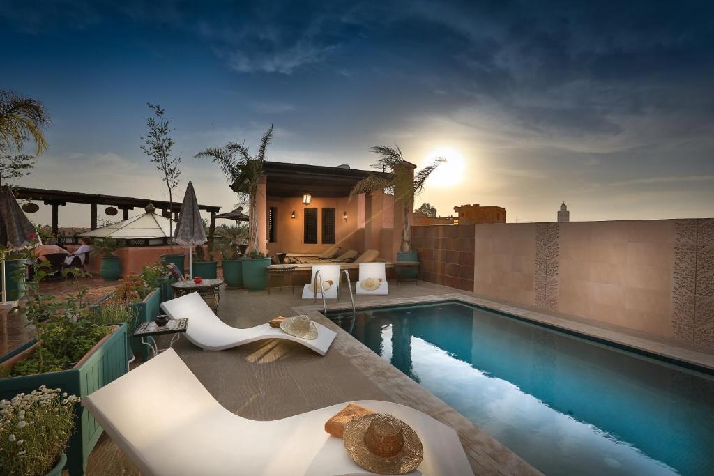 马拉喀什里亚德水疗巴伊亚萨拉姆酒店的一个带游泳池和房子的后院