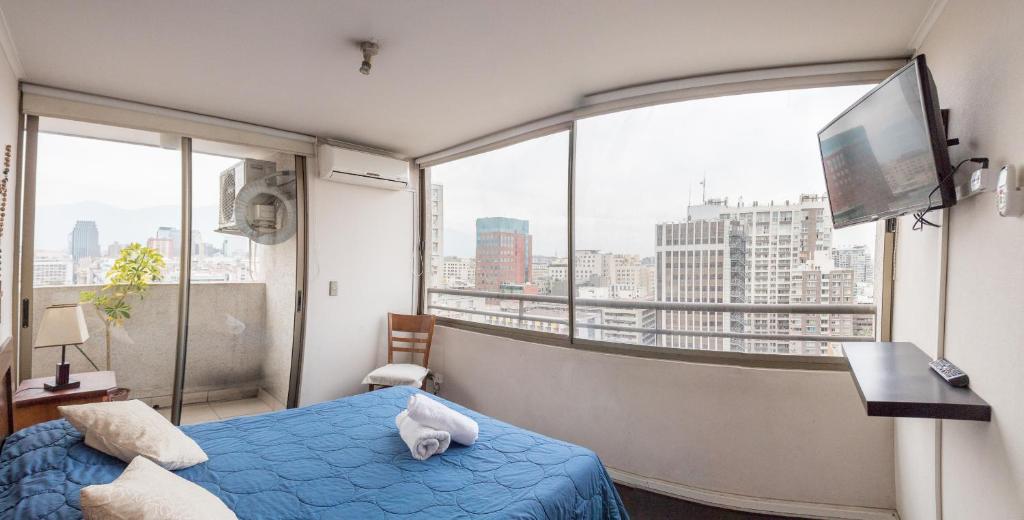 圣地亚哥森特诺公寓酒店的一间卧室设有蓝色的床和大窗户