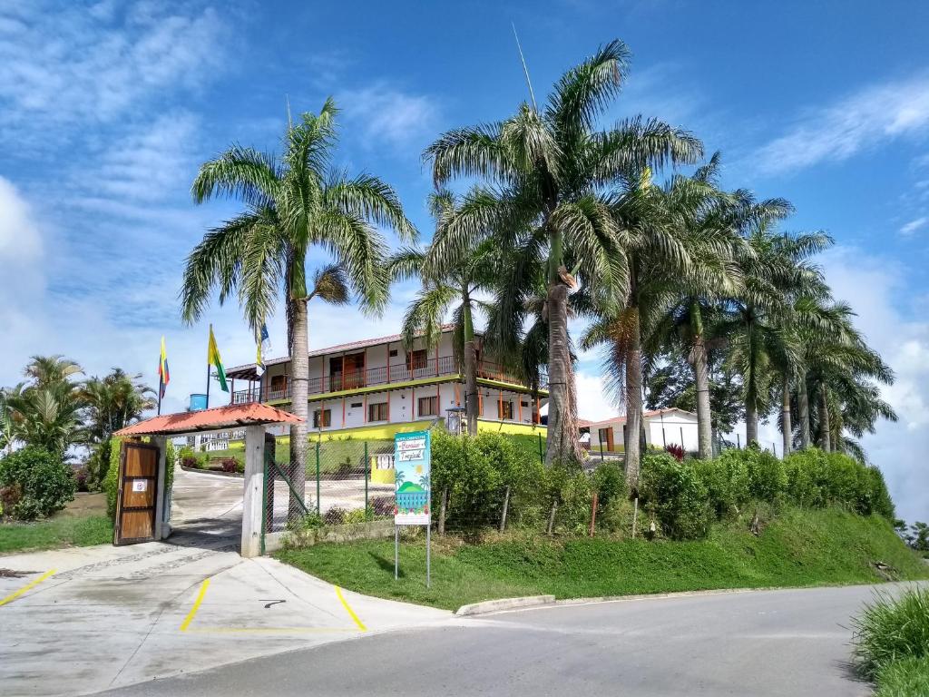 AguadasParaíso Tropical的街道前方有棕榈树的建筑