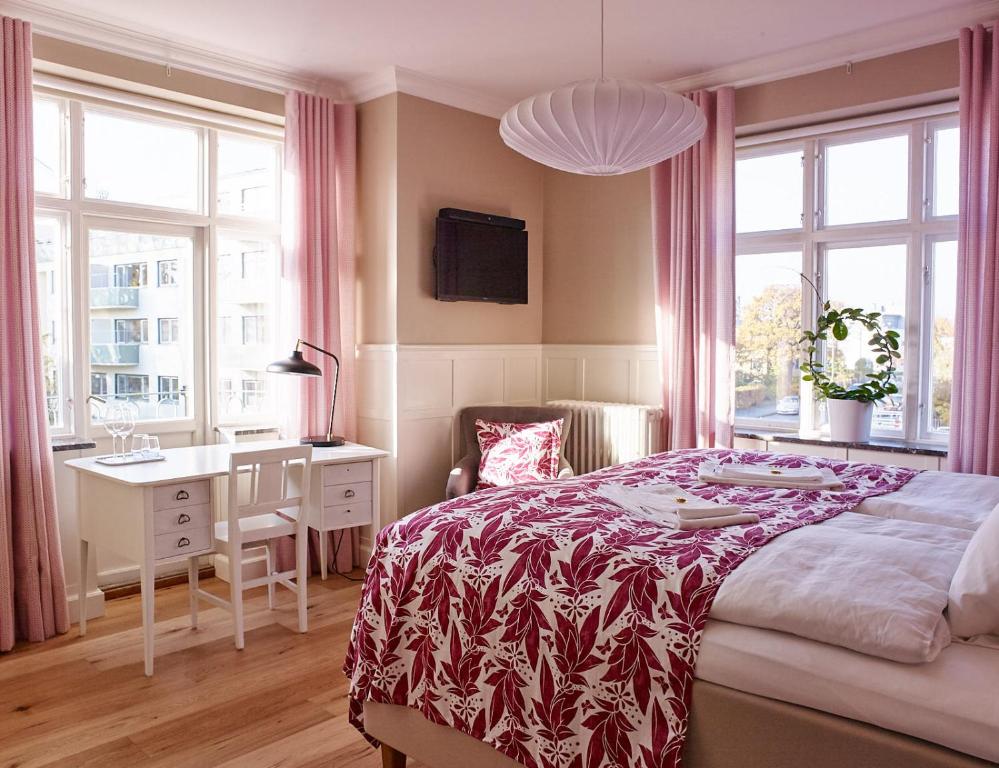 隆德MillasVilla的卧室配有一张床、一张书桌和窗户。