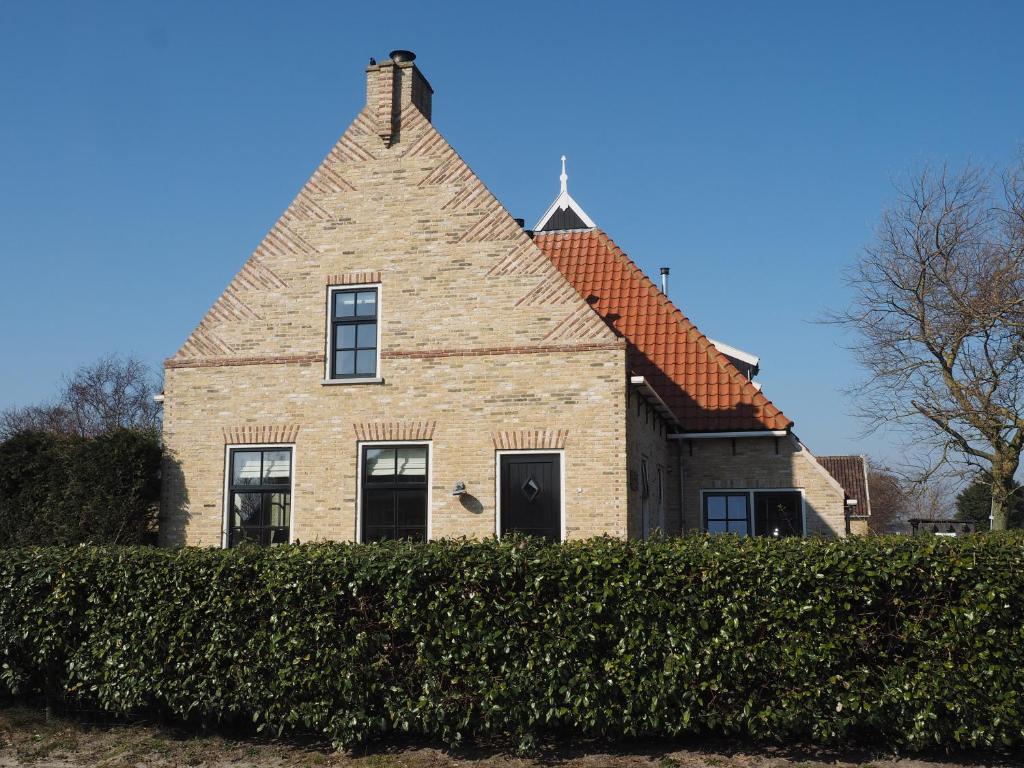 BaaiduinenDe Vergulde Kikker的一座大型砖屋,上面有十字架
