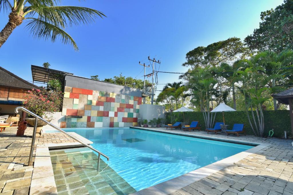 沙努尔Palm Garden Hotel的棕榈树度假村内的游泳池