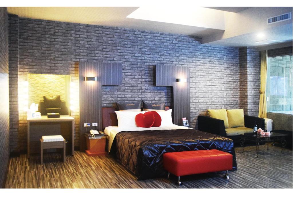 万里区金涌泉温泉汽车旅馆的一间卧室配有一张床、一张沙发和一把椅子