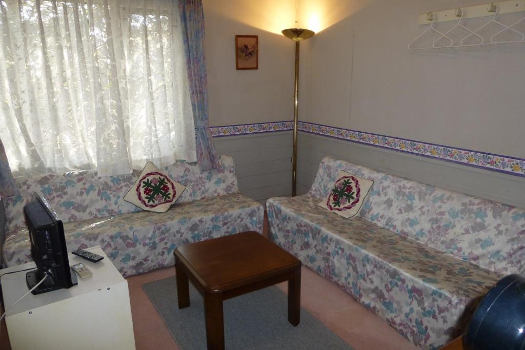 北斗市圣村住宿加早餐旅馆的客厅配有两张沙发和一张桌子