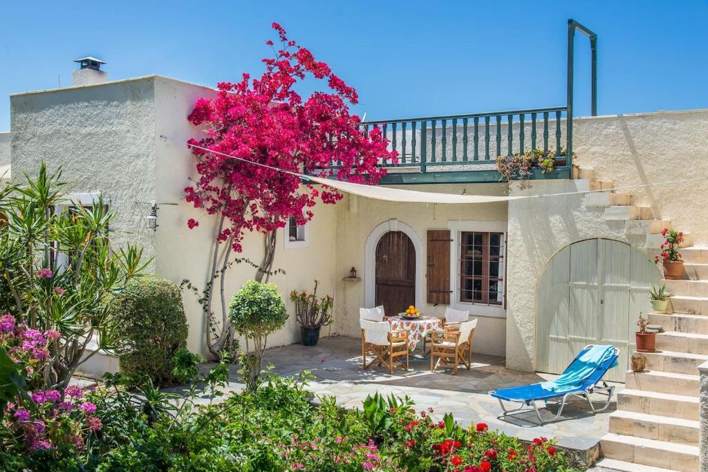 锡蒂亚Bougainvillea House in Crete的一座带桌椅和鲜花的房子