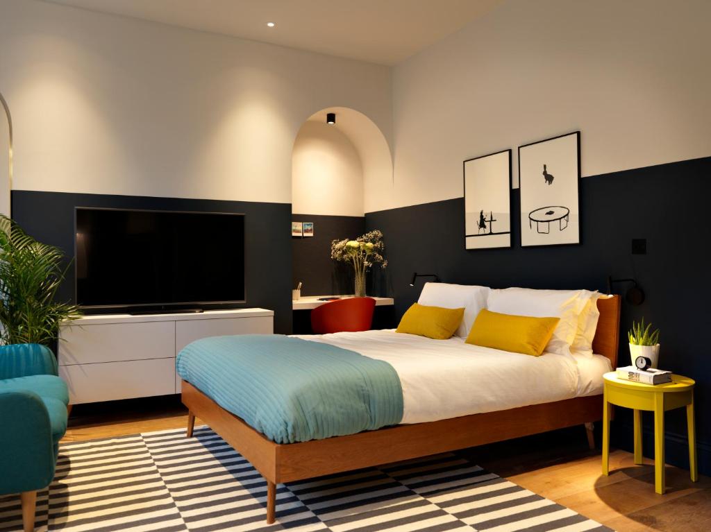 巴斯Student Castle Studio Apartments - Free parking的一间带大床和电视的卧室