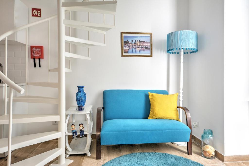 法鲁Blue Barqueta Studio的客厅设有一张蓝色椅子,设有楼梯