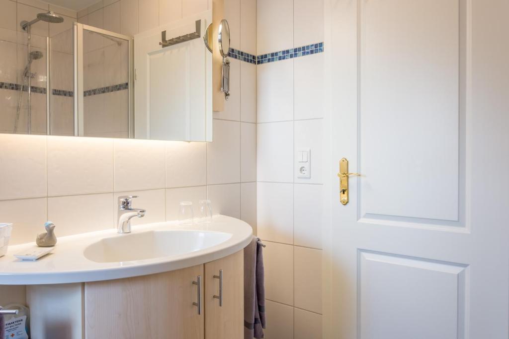 Utersum克努森旅馆的一间带水槽和镜子的浴室
