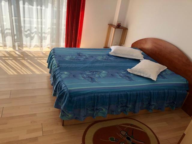 CorabiaHotel Sucidava的一间卧室配有一张带蓝色棉被的床