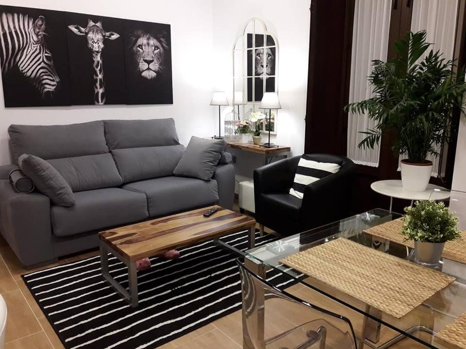 韦尔瓦Periodista Luca de Tena, lujo y confort en pleno centro的客厅配有沙发和桌子