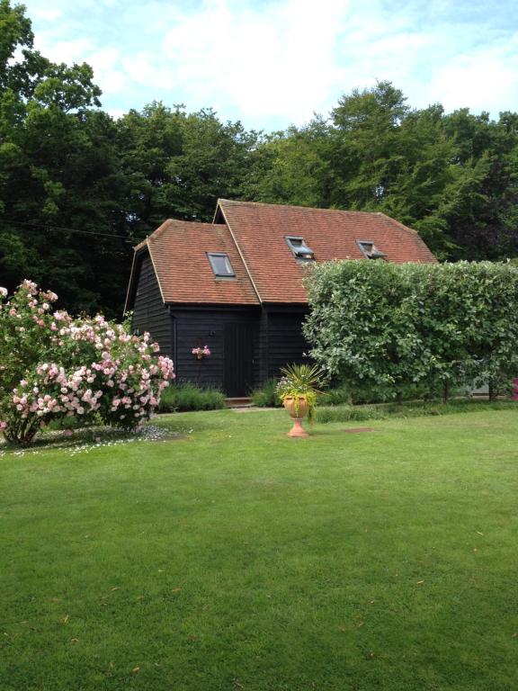 赫特福德Wellrose Barn的一座带绿色庭院的房子